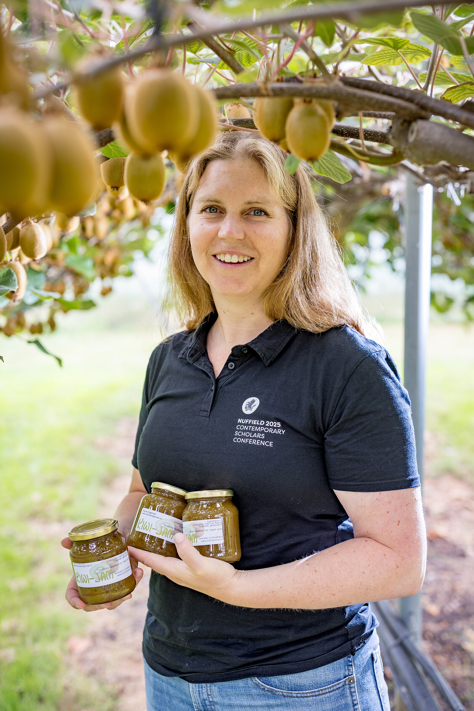Djûke in de kiwiboomgaard, waar zij de de kiwi jam van Boerderij Nieuwslagmaat laat zien